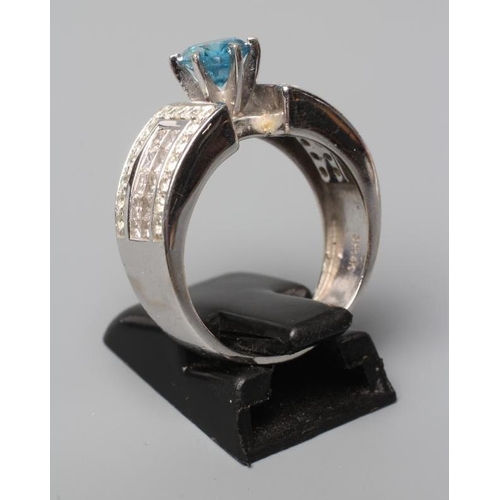 483 - A BLUE AND WHITE DIAMOND COCKTAIL RING, the round brilliant cut blue stone of 0.8cts claw set to ang... 