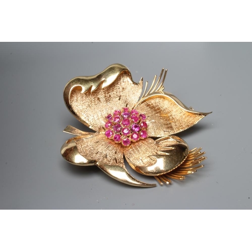 485 - A COCKTAIL BROOCH, the large four petalled flowerhead with numerous small rubies claw set to the cen... 