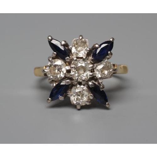 505 - A SAPPHIRE AND DIAMOND DRESS RING, the central cushion cut diamond claw set within a border of four ... 