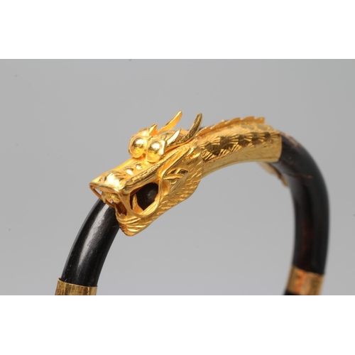 506 - A BANGLE AND MATCHING RING, probably Chinese, possibly lacquered wood, each with a yellow metal drag... 