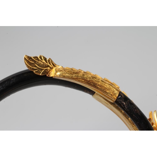 506 - A BANGLE AND MATCHING RING, probably Chinese, possibly lacquered wood, each with a yellow metal drag... 