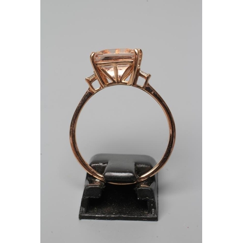 509 - A MORGANITE DRESS RING, the Asscher cut stone claw set and with two small baguette cut stones to eac... 