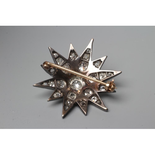 520 - A DIAMOND STAR BROOCH, the central old cut stone of approximately 0.4cts surrounded by twenty four s... 