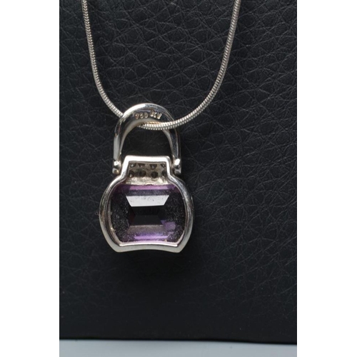 526 - AN AMETHYST AND DIAMOND HANDBAG PENDANT, the facet cut shaped amethyst below eight small pave set di... 