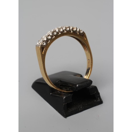 551 - A SEVEN STONE DIAMOND HALF HOOP ETERNITY RING, the brilliant cut stones point set to a plain 18ct go... 