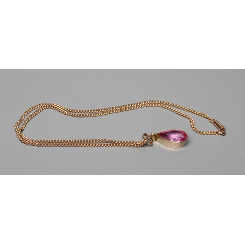 552 - A PINK TOPAZ(?) PENDANT, the facet cut tear shaped stone open back collet set below a seed pearl in ... 