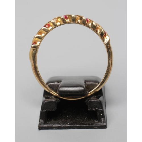 576 - A RUBY AND DIAMOND HALF HOOP RING, channel set with alternating pairs of rubies and diamonds to a pl... 