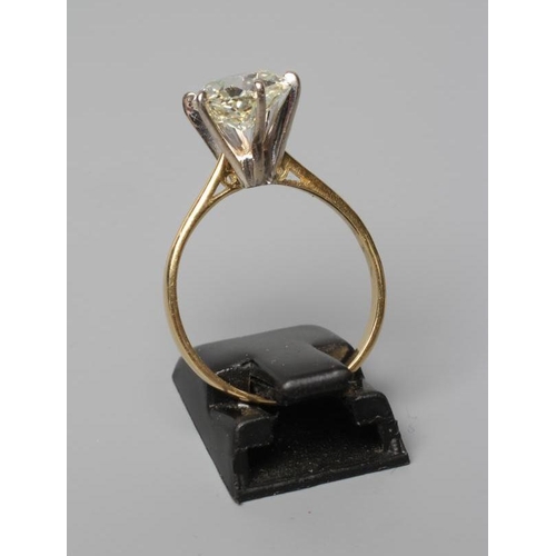 581 - A SOLITAIRE DIAMOND RING, the Victorian cut stone of approximately 3.17cts, claw set to a plain 18ct... 