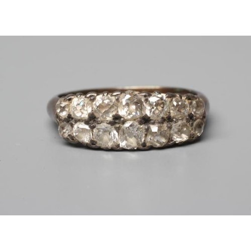 583 - A FOURTEEN STONE DIAMOND RING, the graduated mix cut stones point set in a double line to a plain sh... 