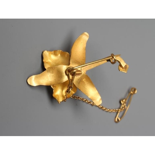 587 - A VENEZUALAN LILY BROOCH centred by a peg set cultured pearl, with safety chain, stamped 18k (Est. p... 