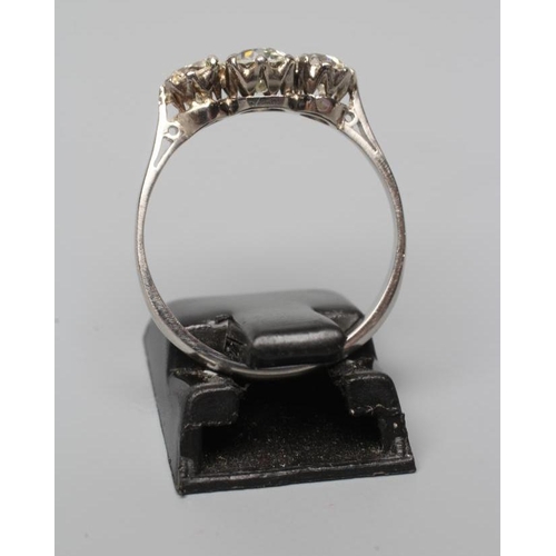 594 - A THREE STONE DIAMOND RING, the old cut stones claw set and totalling approximately 0.8cts, to a pla... 