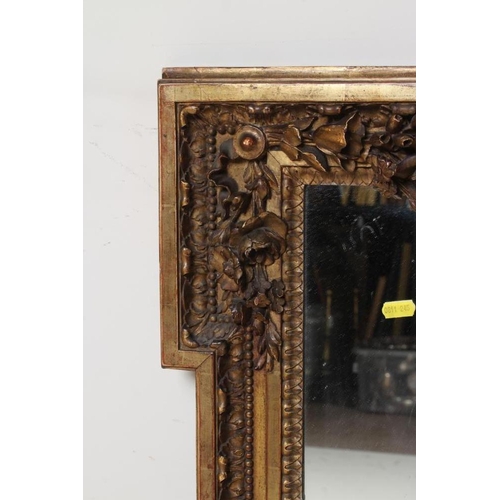 951 - A CARVED GILT WOOD PIER GLASS, 19th century, the oblong plate within a lugged and leaf moulded frame... 