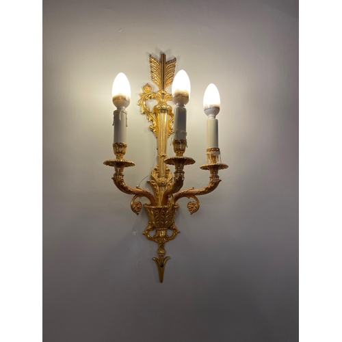 958 - A SET OF FOUR GILT METAL THREE FLAME WALL LIGHTS, 20th century, the wall plate in the form of an arr... 