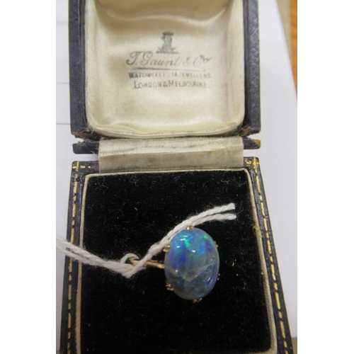 429 - T. GAUNT - a black opal ring, the oval cabochon polished stone claw set to a plain shank, stamped 15... 