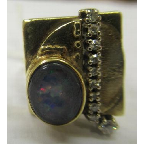 464 - A SECESSIONIST STYLE COCKTAIL RING, the square panel close back collet set with an oval cabochon pol... 