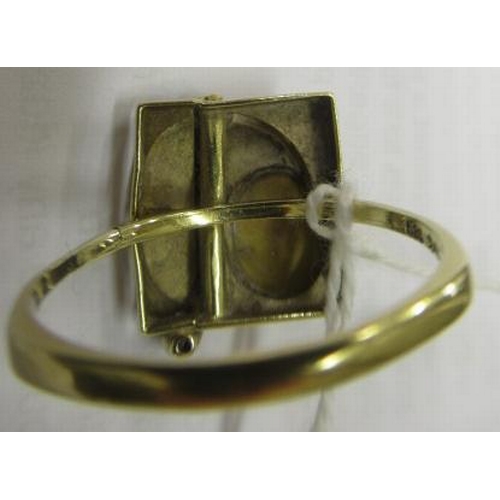 464 - A SECESSIONIST STYLE COCKTAIL RING, the square panel close back collet set with an oval cabochon pol... 