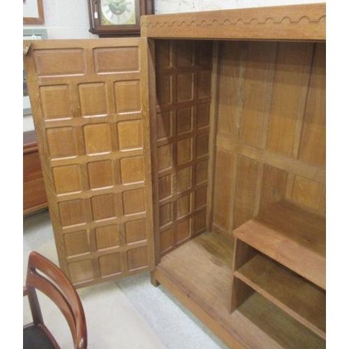 880 - A ROBERT THOMPSON ADZED OAK WARDROBE of oblong multi panelled form with half penny moulded cornice, ... 