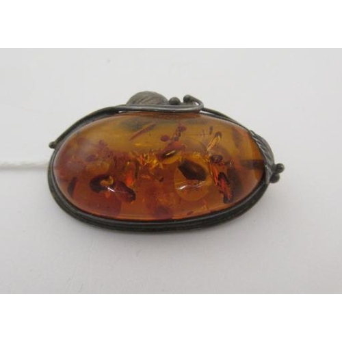 166 - SILVER MOUNTED AMBER BROOCH