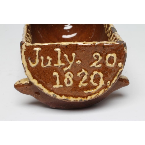 36 - A DOCUMENTARY SLIPWARE CRADLE, 1829, with finial to the hood and applied with S scrolls and hearts, ... 