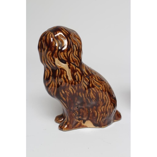 38 - A PAIR OF EARLY VICTORIAN TREACLE GLAZED HEAVY STONEWARE SPANIELS modelled with a free standing fore... 