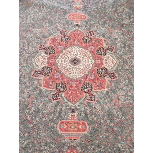 554 - A TURKISH CARPET, modern, the pale green floral ground with central gul in pink, ivory and black wit... 