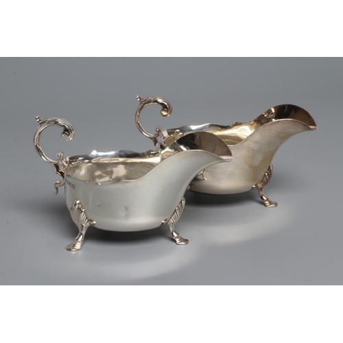 194 - A PAIR OF EDWARDIAN SILVER SAUCEBOATS, maker's mark HA, Sheffield 1907, with shaped everted rims, do... 