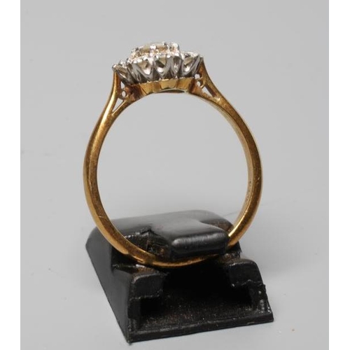 304 - A DIAMOND CLUSTER RING, the central brilliant cut stone of approximately 0.20cts within a border of ... 