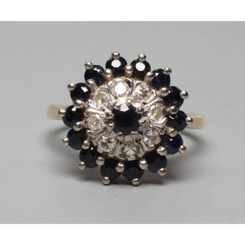 309 - A SAPPHIRE AND DIAMOND CLUSTER RING, the central sapphire within a double border of eight small diam... 