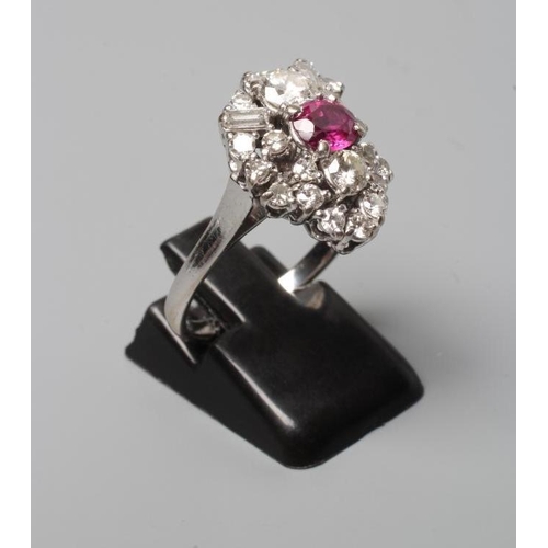 317 - A MODERNIST RUBY AND DIAMOND RING, the central oval facet cut ruby claw set to an abstract border of... 