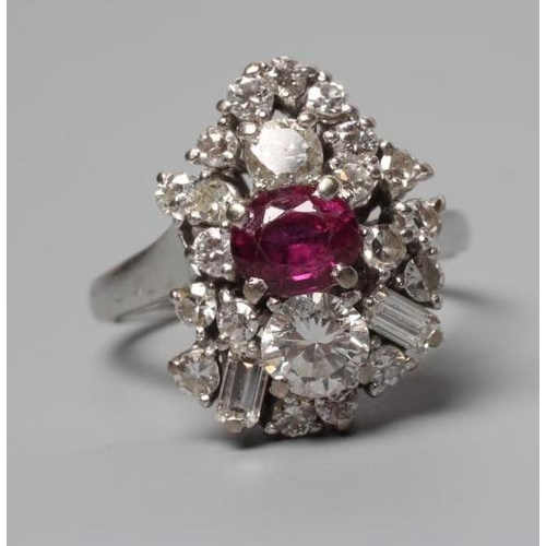 317 - A MODERNIST RUBY AND DIAMOND RING, the central oval facet cut ruby claw set to an abstract border of... 