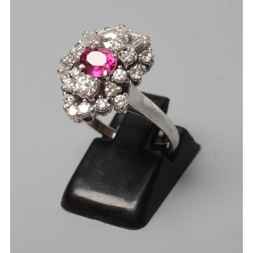 317 - A MODERNIST RUBY AND DIAMOND RING, the central oval facet cut ruby claw set to an abstract border of... 