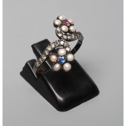 318 - A GEORGIAN STYLE RING, the two off-set flower heads centred by a close back set blue and red stone w... 