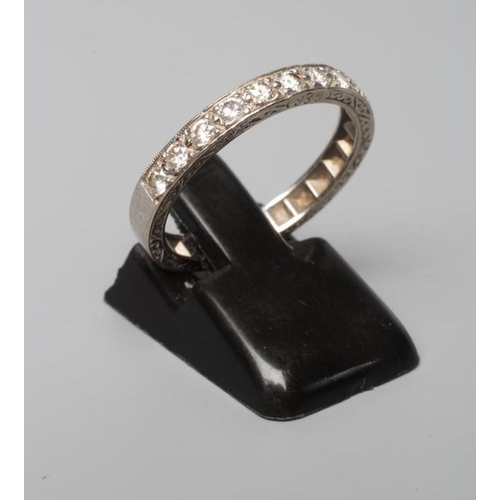 389 - AN ELEVEN STONE DIAMOND HALF HOOP RING, the old cut stones point set to a white shank with scroll en... 