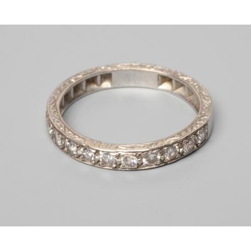 389 - AN ELEVEN STONE DIAMOND HALF HOOP RING, the old cut stones point set to a white shank with scroll en... 