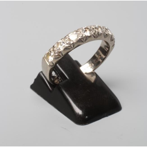 391 - A SEVEN STONE DIAMOND HALF HOOP RING, the brilliant cut stones point set to a plain white 18ct gold ... 