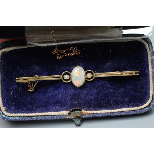 392 - AN EDWARDIAN OPAL AND SEED PEARL BAR BROOCH, the claw set oval cabochon polished opal flanked by two... 