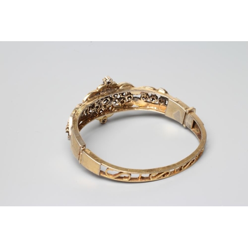 411 - A DIAMOND STIFF HINGED BANGLE, the open upper section set with numerous mix cut stones in rub-over s... 