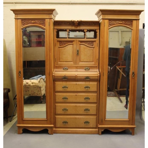 838 - A VICTORIAN STRIPPED WALNUT TRIPLE WARDROBE comprising a pair of hanging compartments each with mirr... 