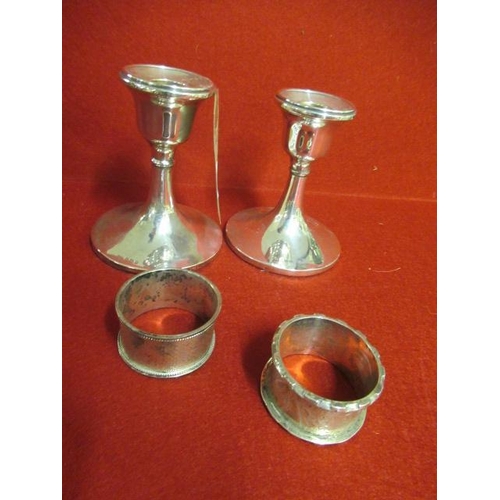 283 - TWO SILVER CANDLESTICKS AND TWO NAPKIN RINGS