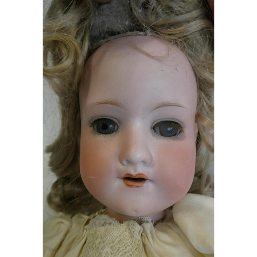 104 - An Armand Marseille bisque socket head doll, with blue glass sleeping eyes, open mouth, teeth, blond... 