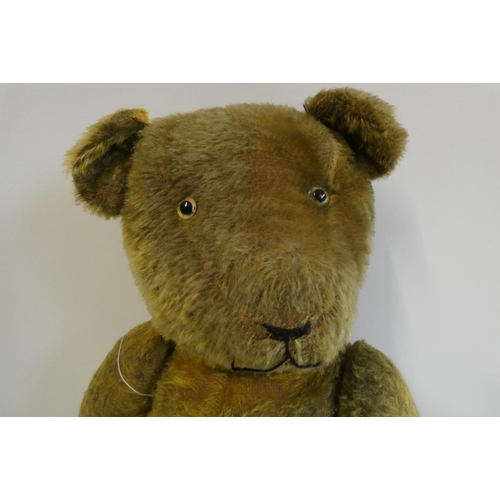 112 - Pre-war jointed teddy bear, with clear glass eyes, orange plush sewn nose and felt pads, 26