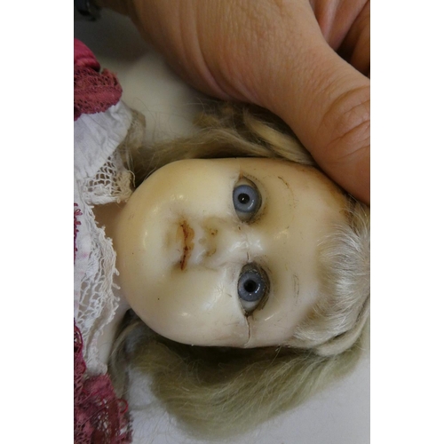 18 - A Victorian wax shoulder head doll, with blue glass eyes, blond hair, closed mouth, kid body and ori... 