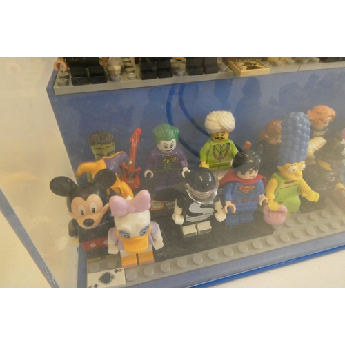 229 - A perspex display case of Lego figures, comprising 68 characters, 3 cats, an owl and a penguin, inlc... 