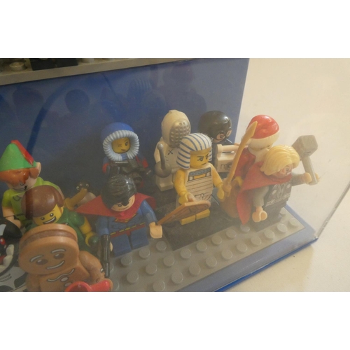 229 - A perspex display case of Lego figures, comprising 68 characters, 3 cats, an owl and a penguin, inlc... 