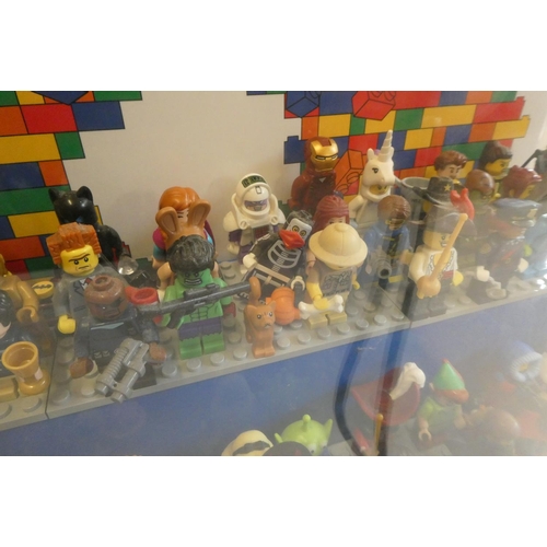 229 - A perspex display case of Lego figures, comprising 68 characters, 3 cats, an owl and a penguin, inlc... 