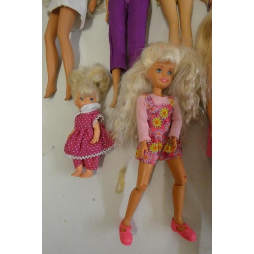 26 - Twelve Barbie dolls, comprising ten Barbies, two younger sisters and a Barbie camera