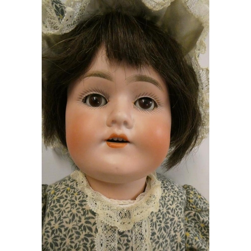 34 - A Schoenau & Hoffmeister bisque socket head doll, with brown glass sleeping eyes, open mouth, teeth,... 