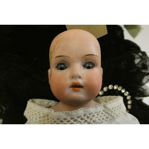 58 - A composition shoulder head doll with fixed blue glass eyes, closed mouth, pierced ears, later brown... 