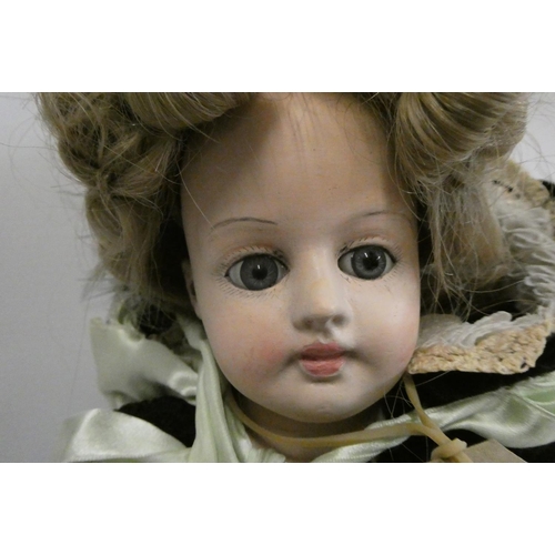 58 - A composition shoulder head doll with fixed blue glass eyes, closed mouth, pierced ears, later brown... 