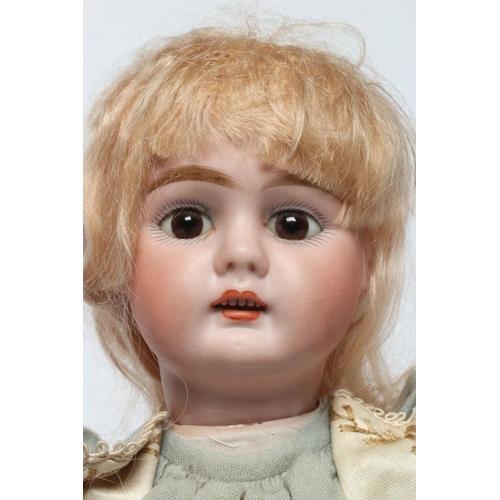 86 - A bisque socket head doll, possibly Kestner, with brown glass fixed eyes, open mouth, teeth, pierced... 